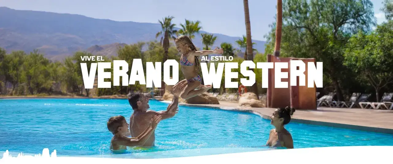 Familia disfrutando de un chapuzón en el parque oasis Almería, viviendo el verano al estilo western.