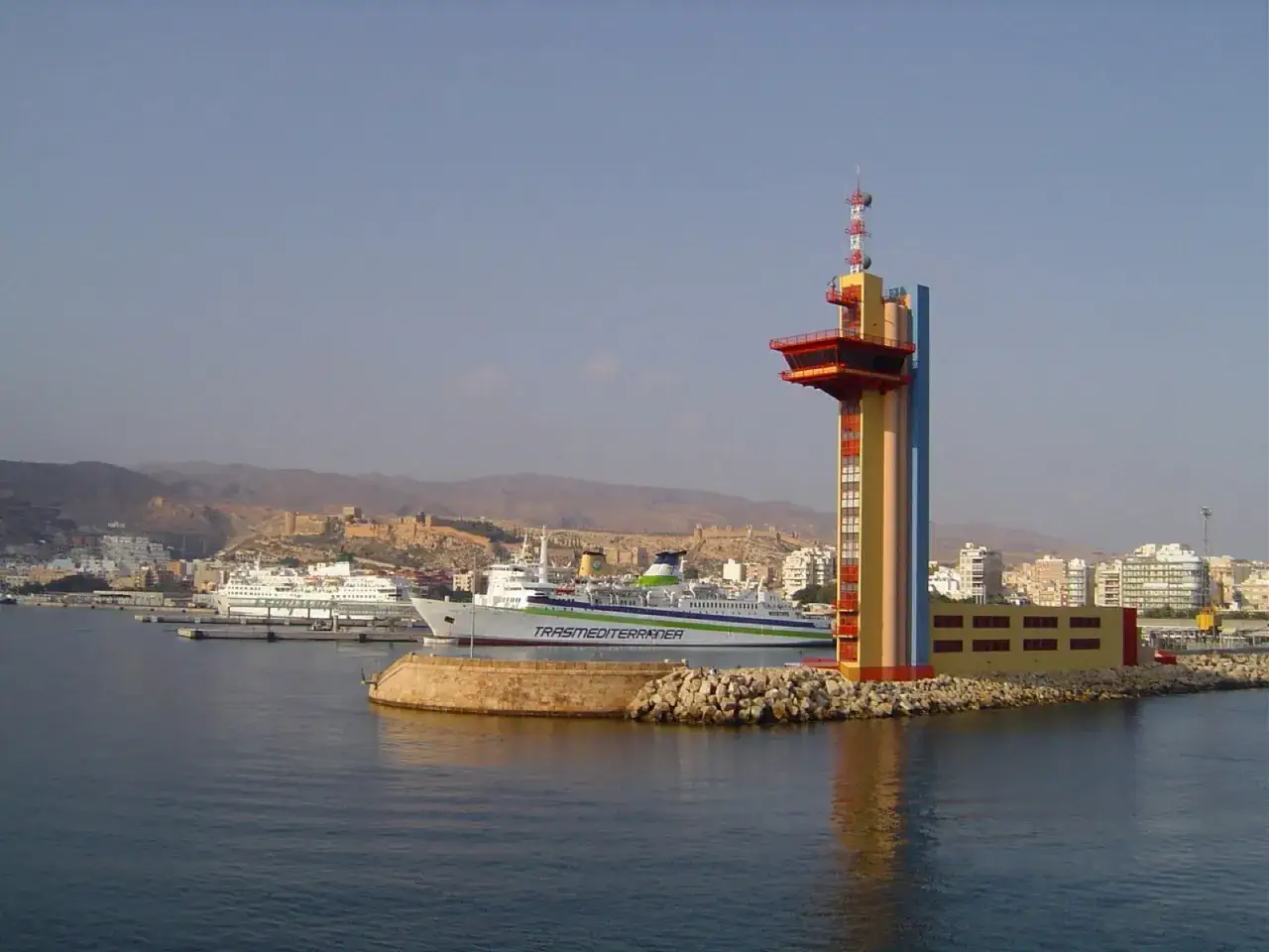 Torre de control y ferry en el puerto. Un buen lugar que ver en Almería capital, con la Alcazaba al fondo.
